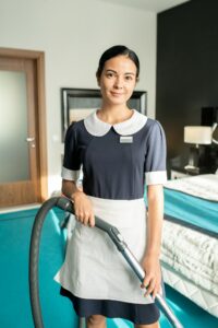 Beautiful chambermaid with vacuum cleaner